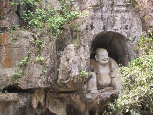 Laughing Buddha carving at the Buddhist temple and caves in Hangzhou